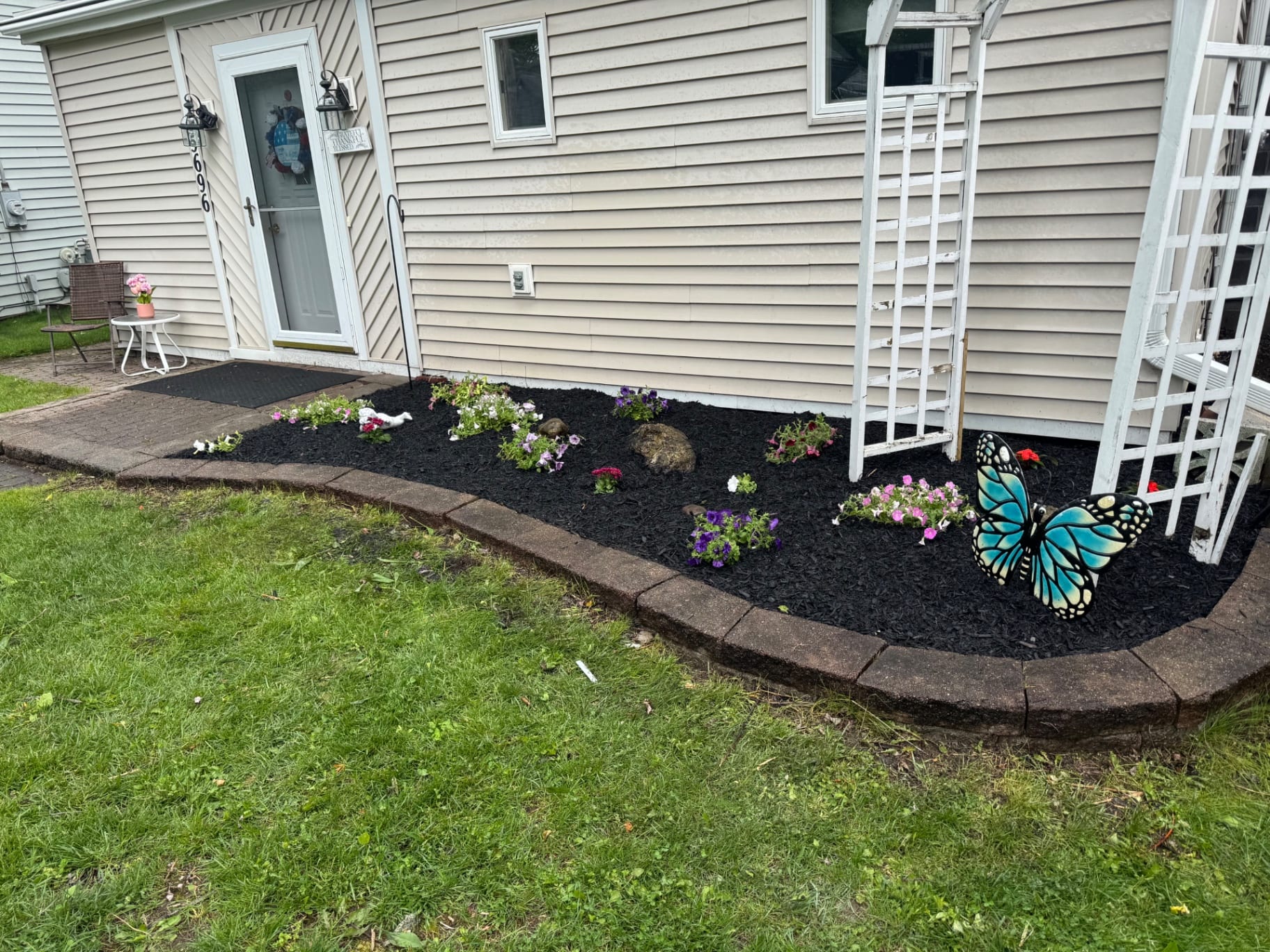 Front entry flower bed refreshed with black mulch and seasonal flowers